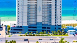 Um hotel com vários andares, um elemento vertical central e uma garagem.