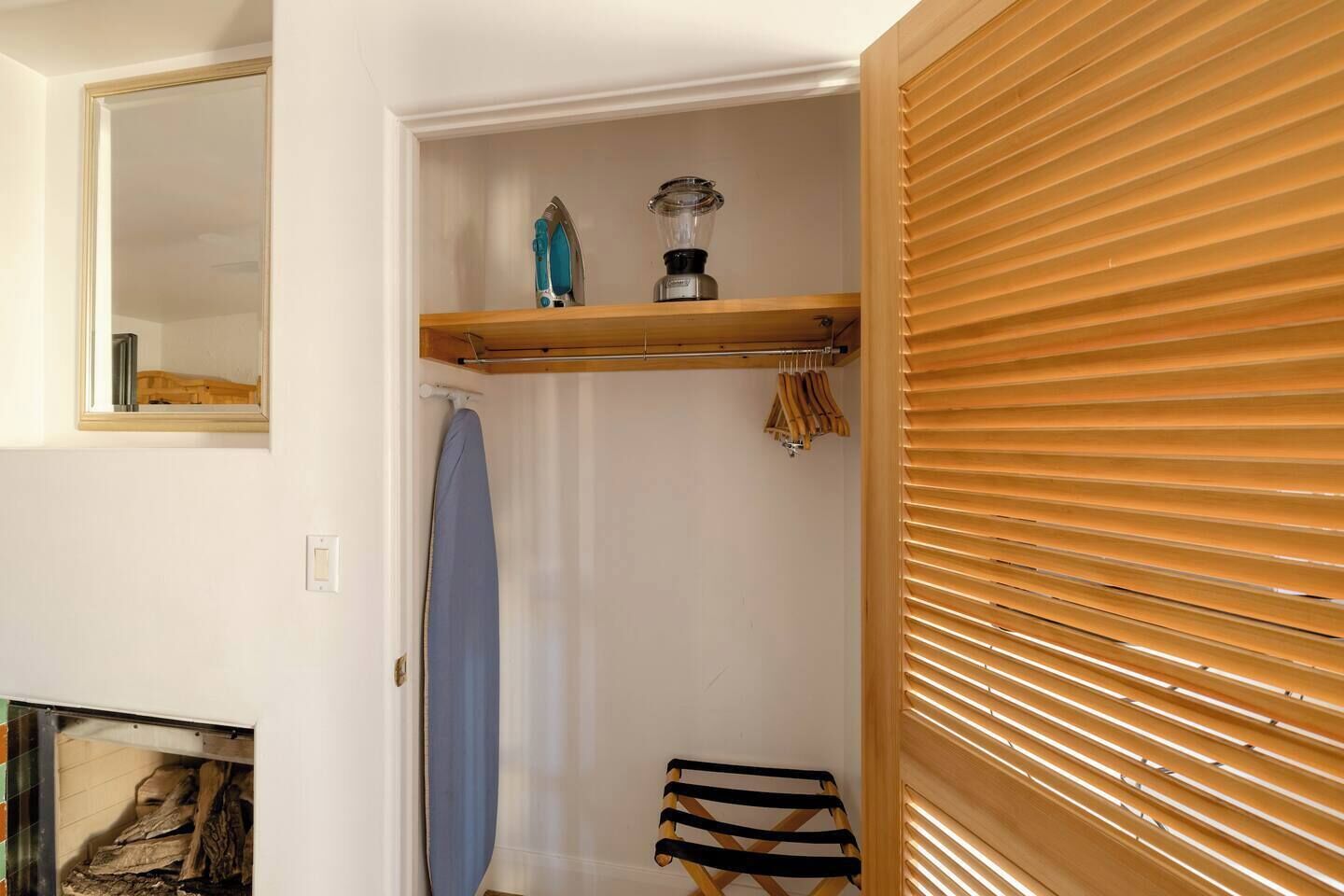 A bathroom with a wooden vanity, a shower curtain, and a hanging towel rack.