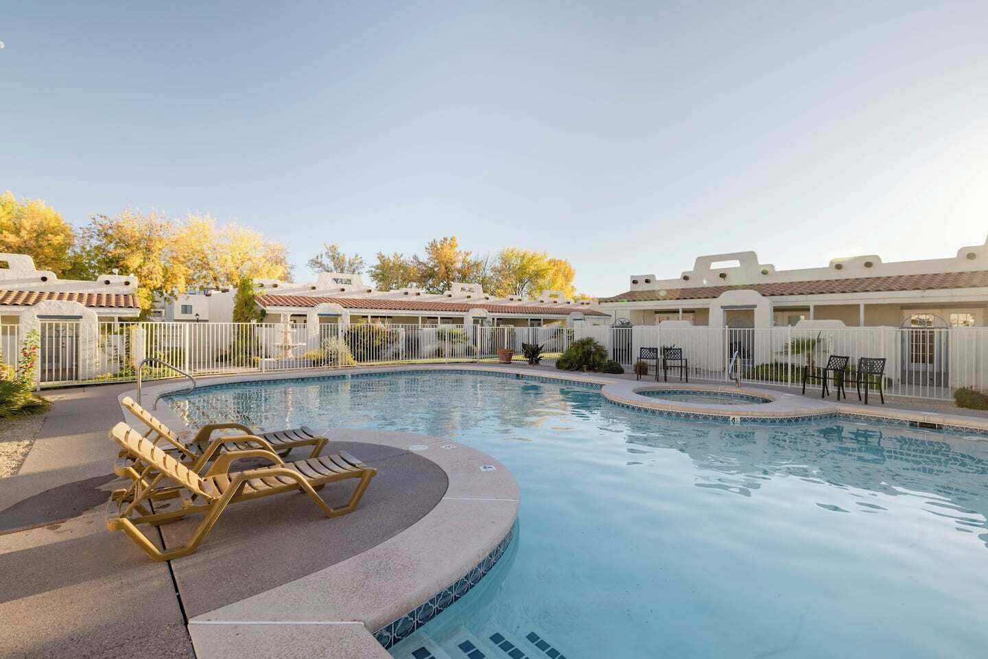 Une piscine avec des chaises longues et un patio clos.