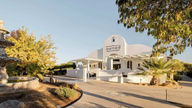 A spa with a white exterior, a bell tower, and a fountain in the foreground. - Luxury Studio | Pool, Spa & Fireplace (St. George)