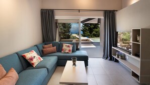 Een moderne woonkamer met een hoekbank, een bijzettafeltje en uitzicht op een balkon met buitenmeubilair.