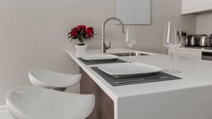 A modern kitchen with a white countertop, a stainless steel sink, and a potted plant. - Modern 1BR Period Property in Kensington (London)