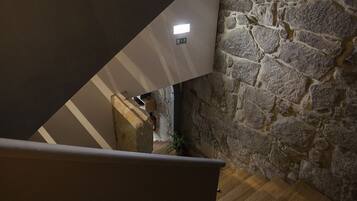 A staircase with stone walls and a wooden floor.