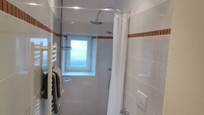 Ein modernes Badezimmer mit Dusche, Toilette und Badewanne.