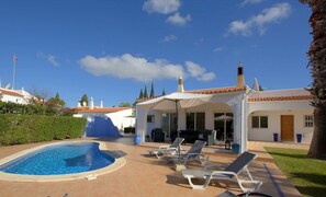A swimming pool with lounge chairs, a covered patio, and a white building with a tiled roof. - 16 Centeanes Fabulous Location Just Short Walk to the Beach (Carvoeiro)