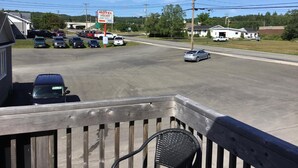 Un motel con un letrero, coches aparcados y cielo despejado.