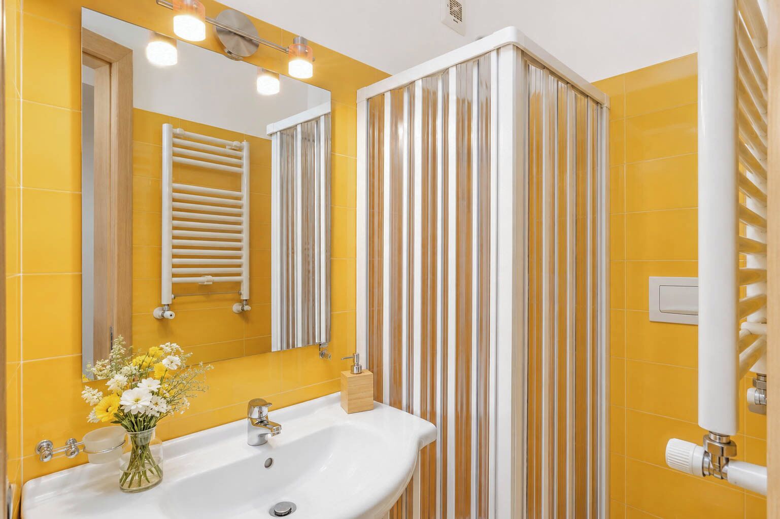 A bathroom with a white sink, mirror, and striped shower curtain.