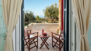 Ein Balkon mit Tisch für zwei Personen, einer Flasche und einer Obstschale.