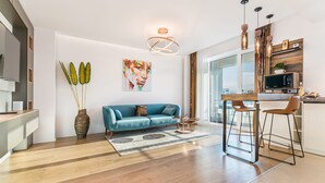 A modern kitchen with a wooden countertop, a built-in microwave, and a bar stool. - MK Apartments Brasov (Brasov)