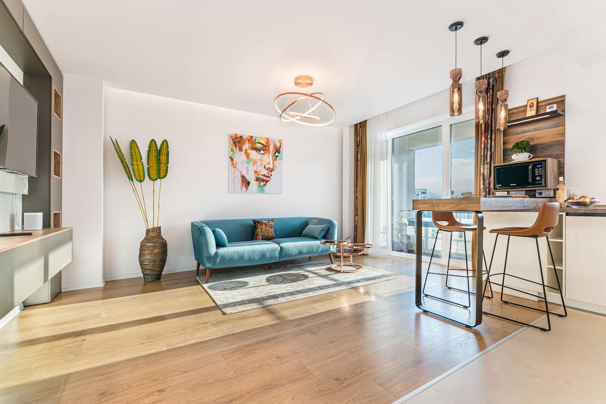 Una cocina moderna con encimera de madera, microondas integrado y un taburete de bar.