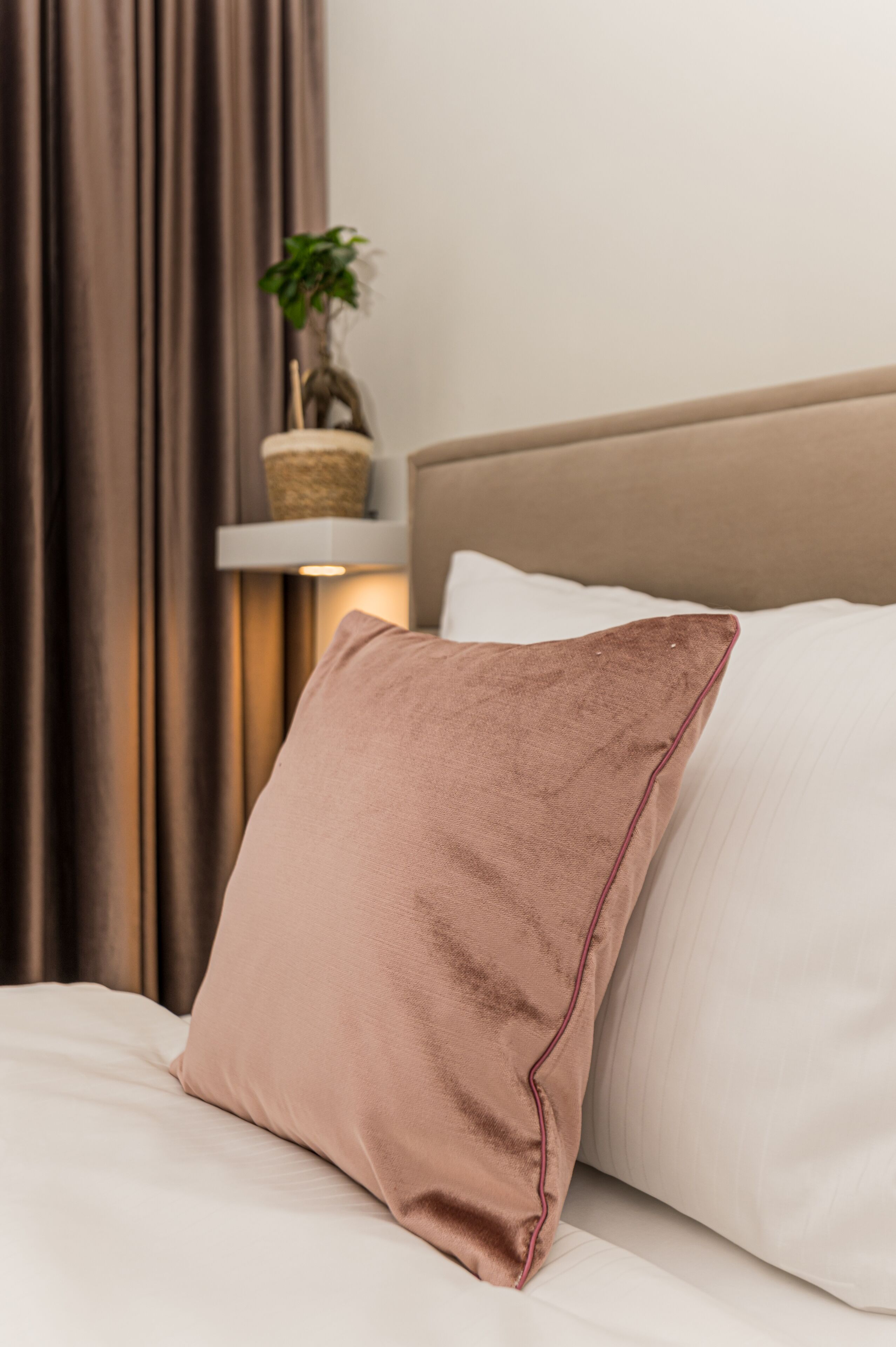 A bed with a single pillow and a white pillow on a white bedspread.