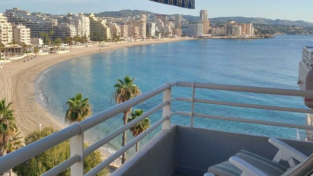 Un balcón con vista a la playa y al paisaje urbano.