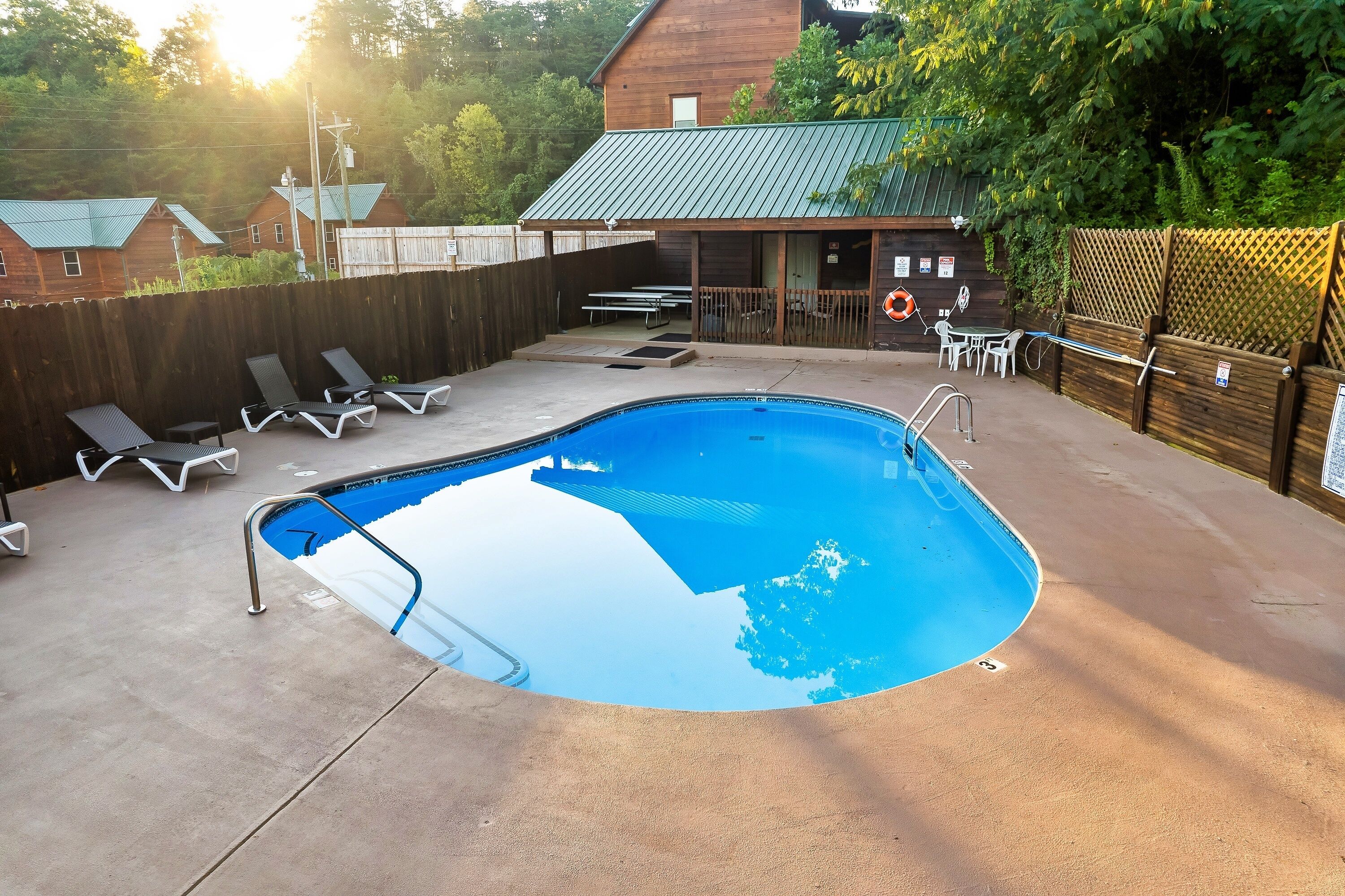 A swimming pool with lounge chairs and a covered patio area.