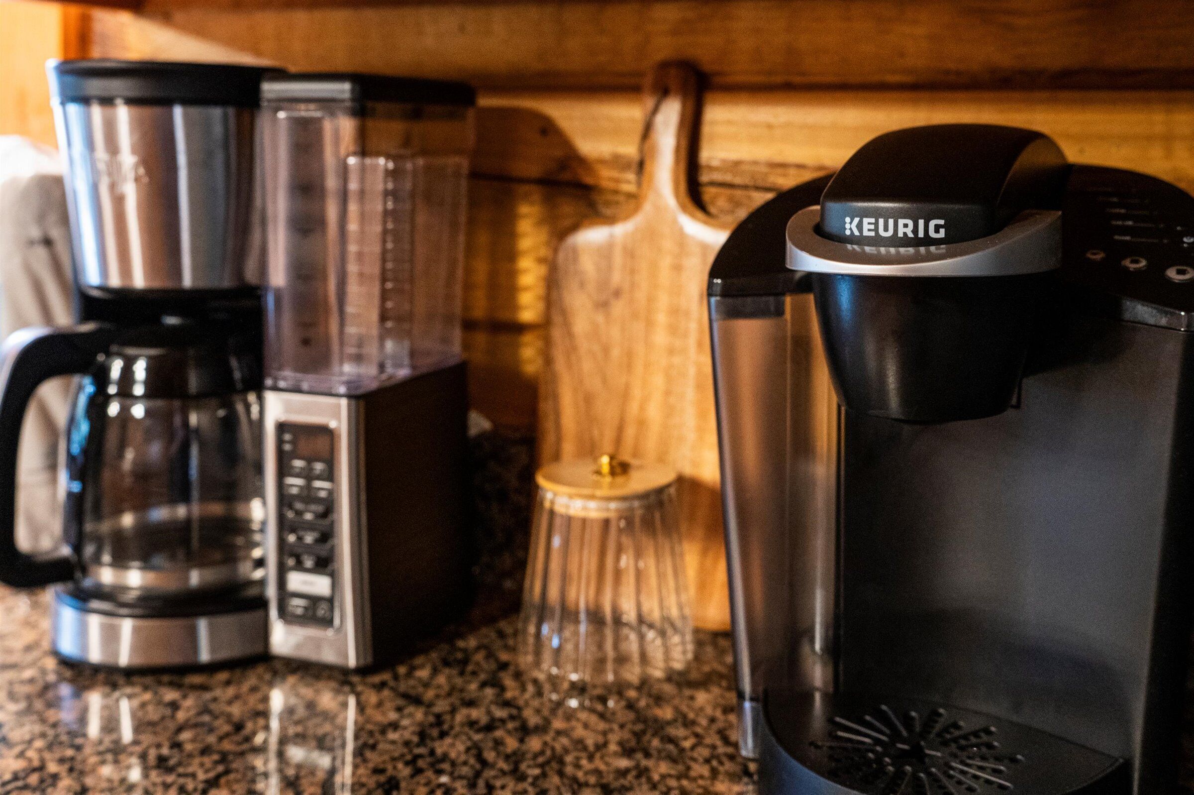 Una cafetera, una licuadora y una jarra de vidrio sobre la encimera de la cocina.