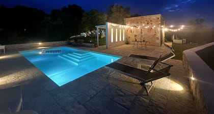 White stone typical apulian villa with barrel roof surrounded by olive trees.