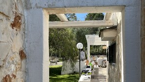 Un área de patio al aire libre con una pérgola, muros de piedra y un letrero con un símbolo de corazón.