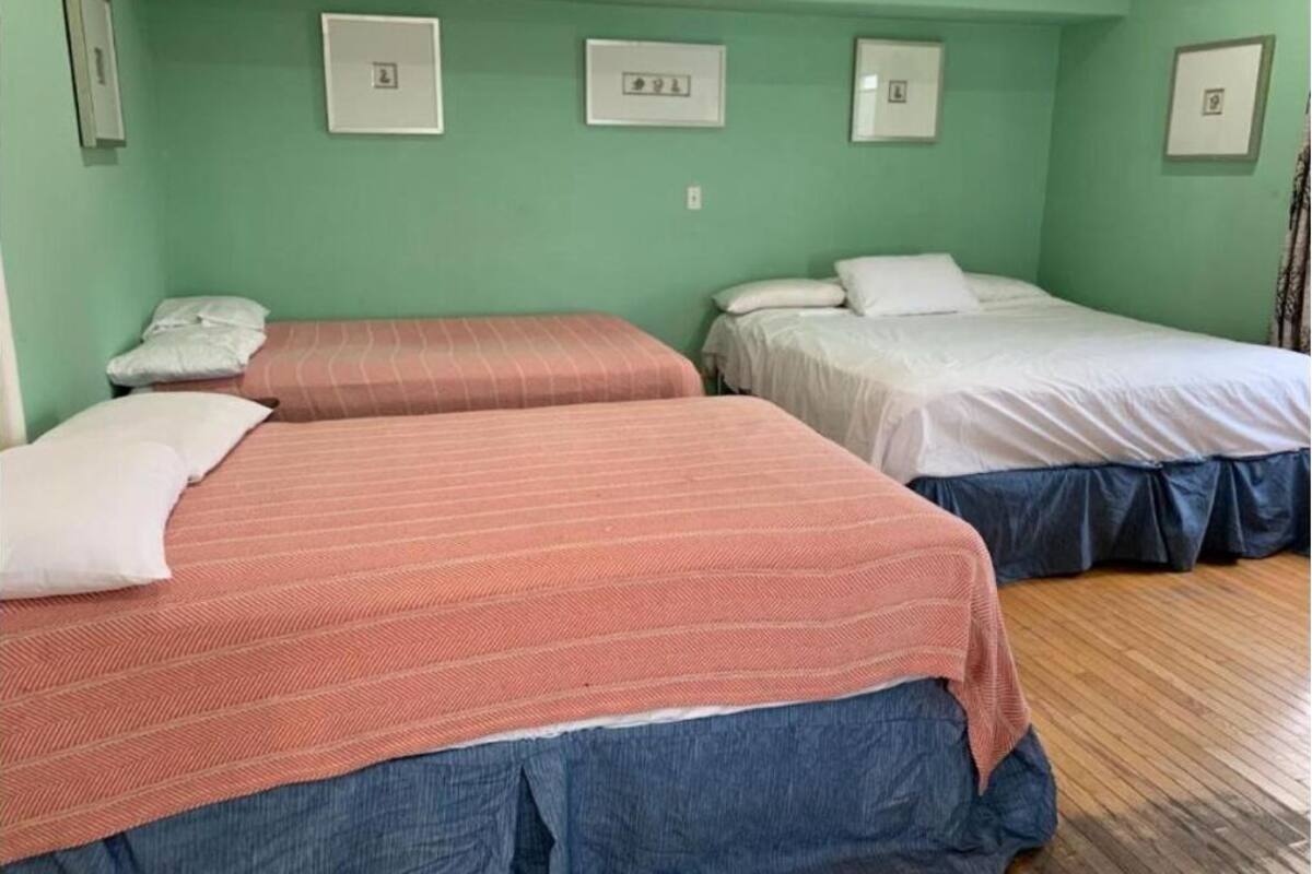A room with two beds, each with a different colored bedspread.
