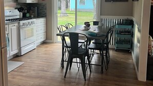 A kitchen with a dining area, a large window, and a view of the backyard. - Beach Melody, Long Beach WA (Long Beach)