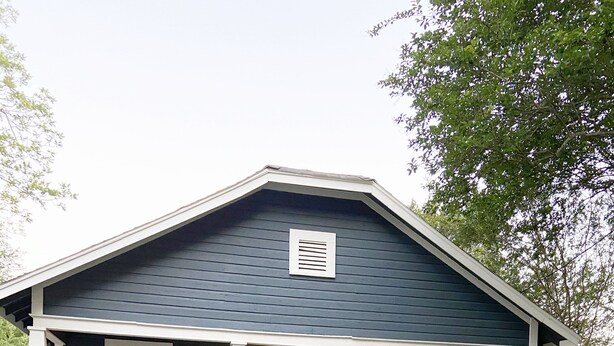 A two-story house with a front porch, a brick foundation, and a white picket fence. - Historic Bungalow! 2bed, 2bath, 2den, Downtown Humble, IAH 8min! (Humble)