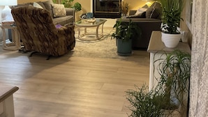 Un salon doté d’une cheminée, d’un ventilateur de plafond et d’un téléviseur à écran plat.