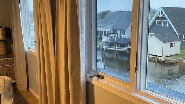 Une pièce avec vue sur un quai et un petit bâtiment.