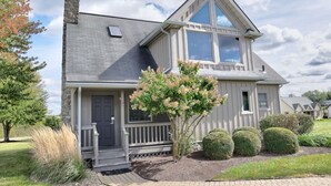 A two-story house with a stone facade, a front porch, and a well-maintained garden. - Amish Country Getaway With Seasonal Pool/Hot Tub (Millersburg)