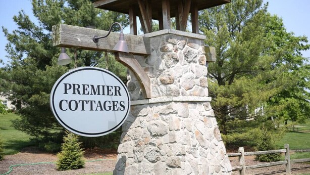 Uma construção de pedra com uma placa que diz 'Premier Cottages'.