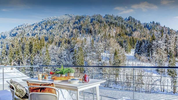 A balcony with a table set for breakfast, overlooking a snowy mountain landscape. - Chalet Ysopi - modern ski base for 9 La Clusaz - OVO Network (Saint-Jean-de-Sixt)
