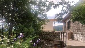 Ein Steinhaus mit einer Holztreppe, die zu einem Balkon führt.