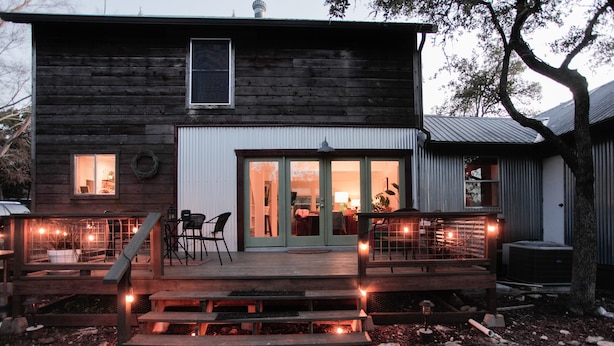 Una casa in legno con veranda, patio coperto e un'ampia finestra.