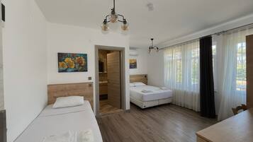 Habitació triple, balcó, vistes al jardí | Minibar i espai de treball apte per a portàtils