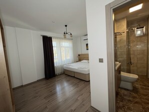 A bedroom with a bed, a shower, and a window with curtains. - Parli Hotel (Gökçeada)