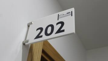 Una placa con el número de habitación 202, colocada en una pared blanca.