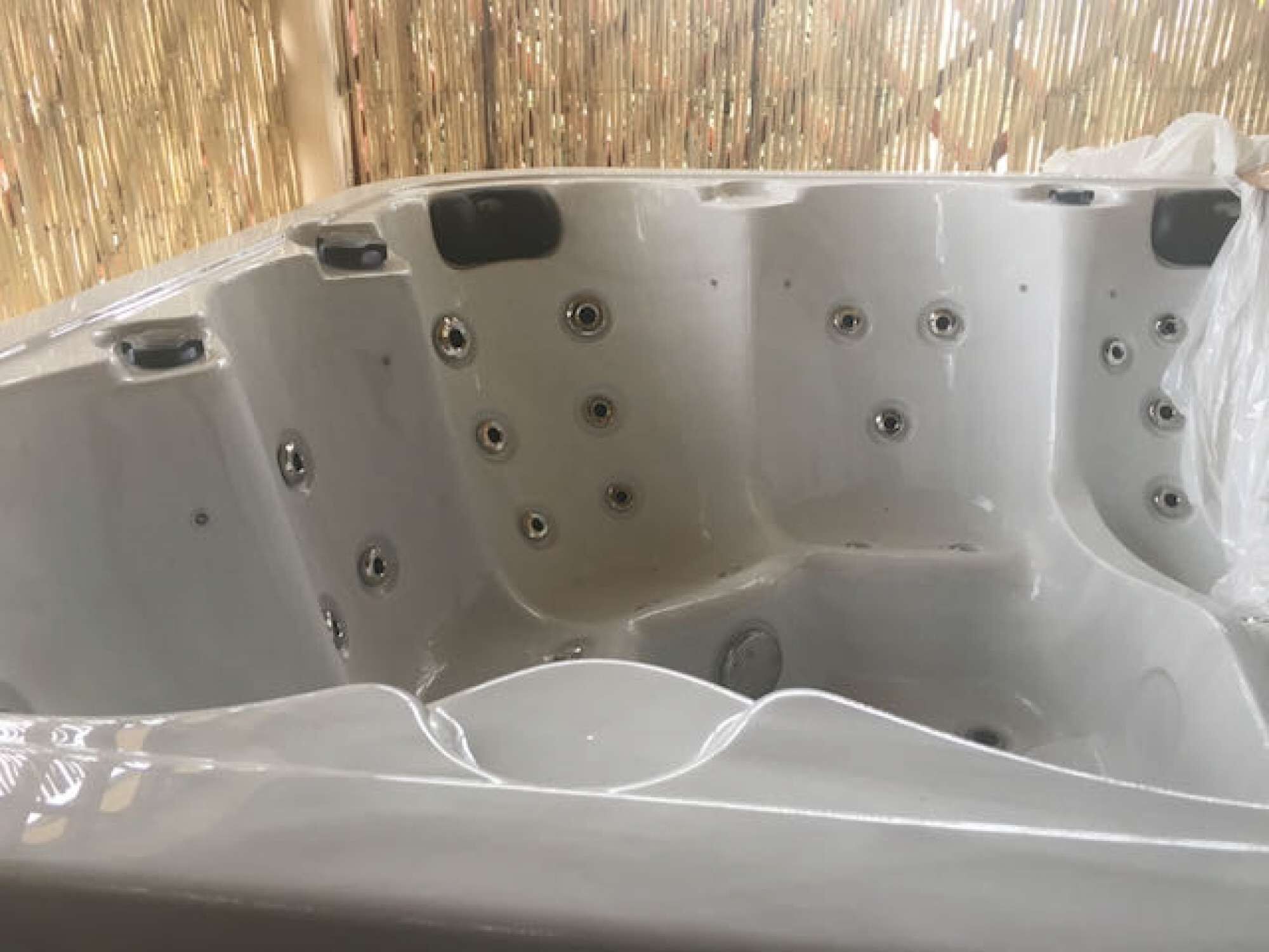 A large, empty hot tub with multiple jets.