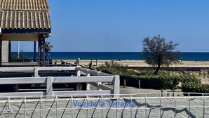 A beach view with a covered seating area and a view of the sea.