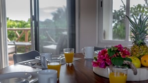 Une table de petit-déjeuner avec des assiettes, des verres et un saladier de fruits.