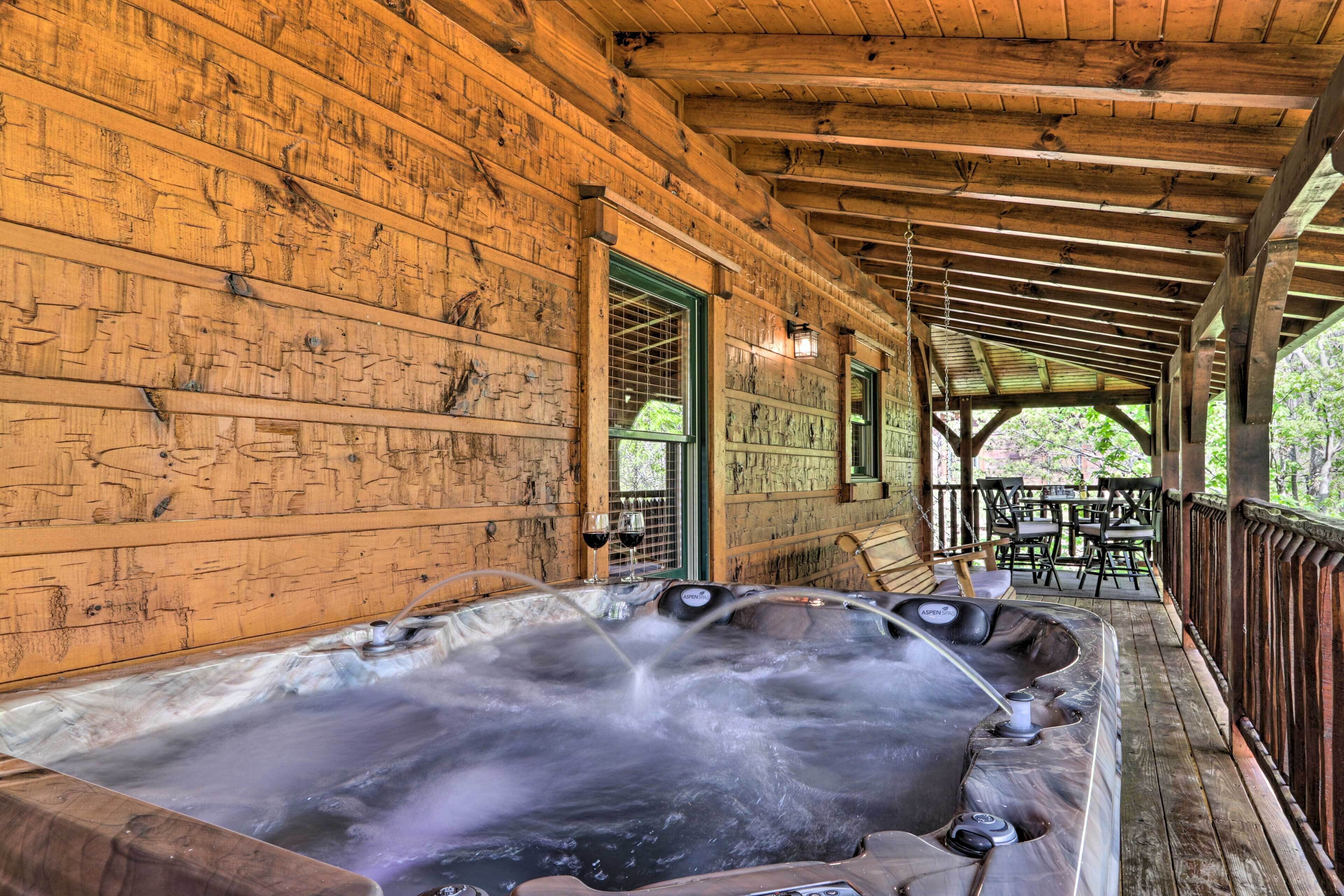Una cabaña de madera con jacuzzi y zona de estar al aire libre.