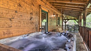 Una cabaña de madera con jacuzzi y zona de estar al aire libre.