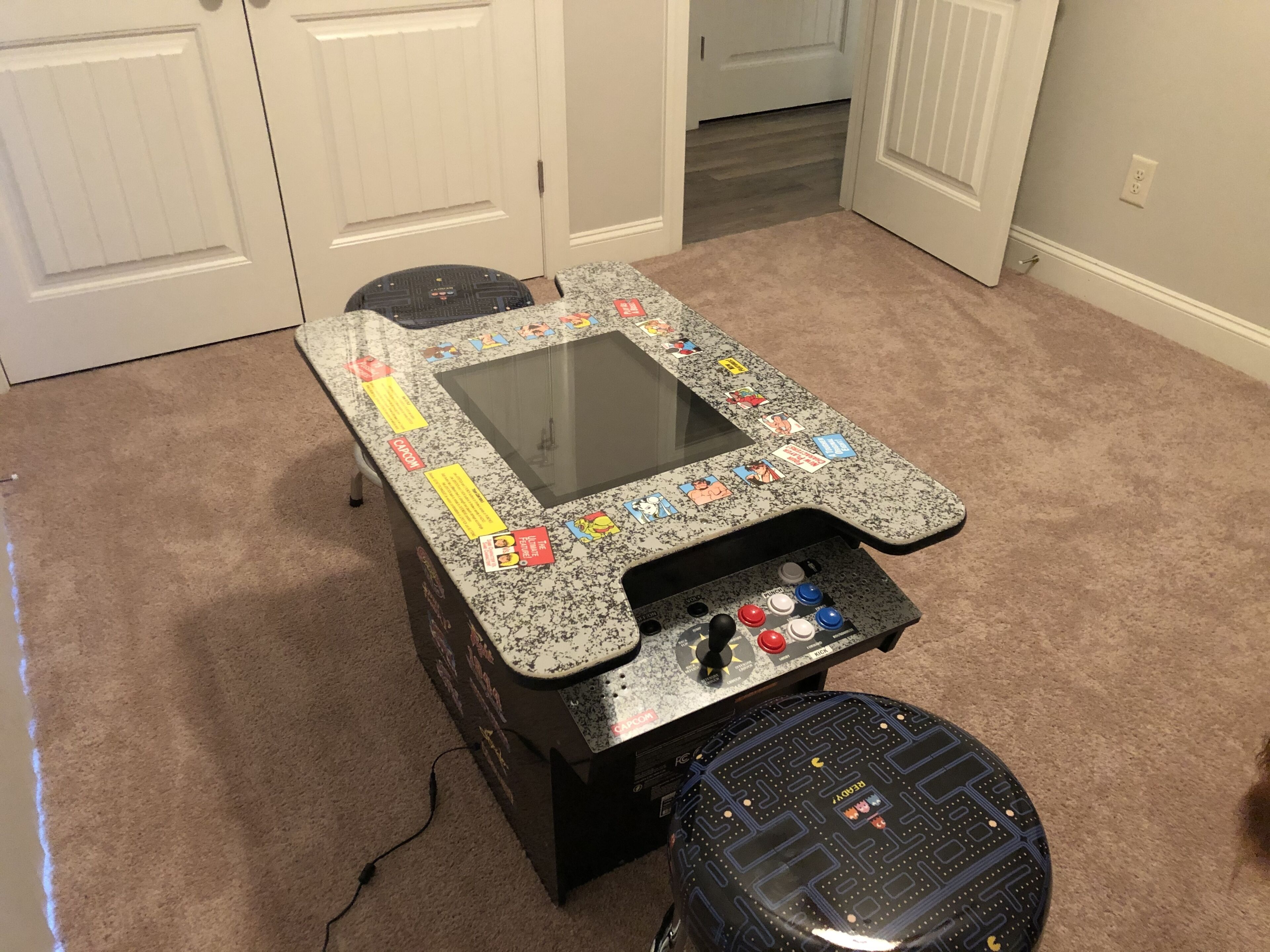 Una mesa de juegos con superficie de vidrio, panel de control y pedal.