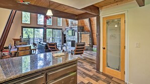 Una cocina con encimera de granito, vigas de madera en el techo y vistas al exterior.