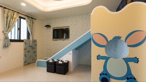 A children's playroom with a slide, a television, and a cartoon character decoration. - Sugar Baby B&B (Wujie)
