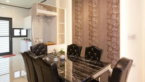 A dining area with a black marble table and four upholstered chairs. - Candy House (Wujie)