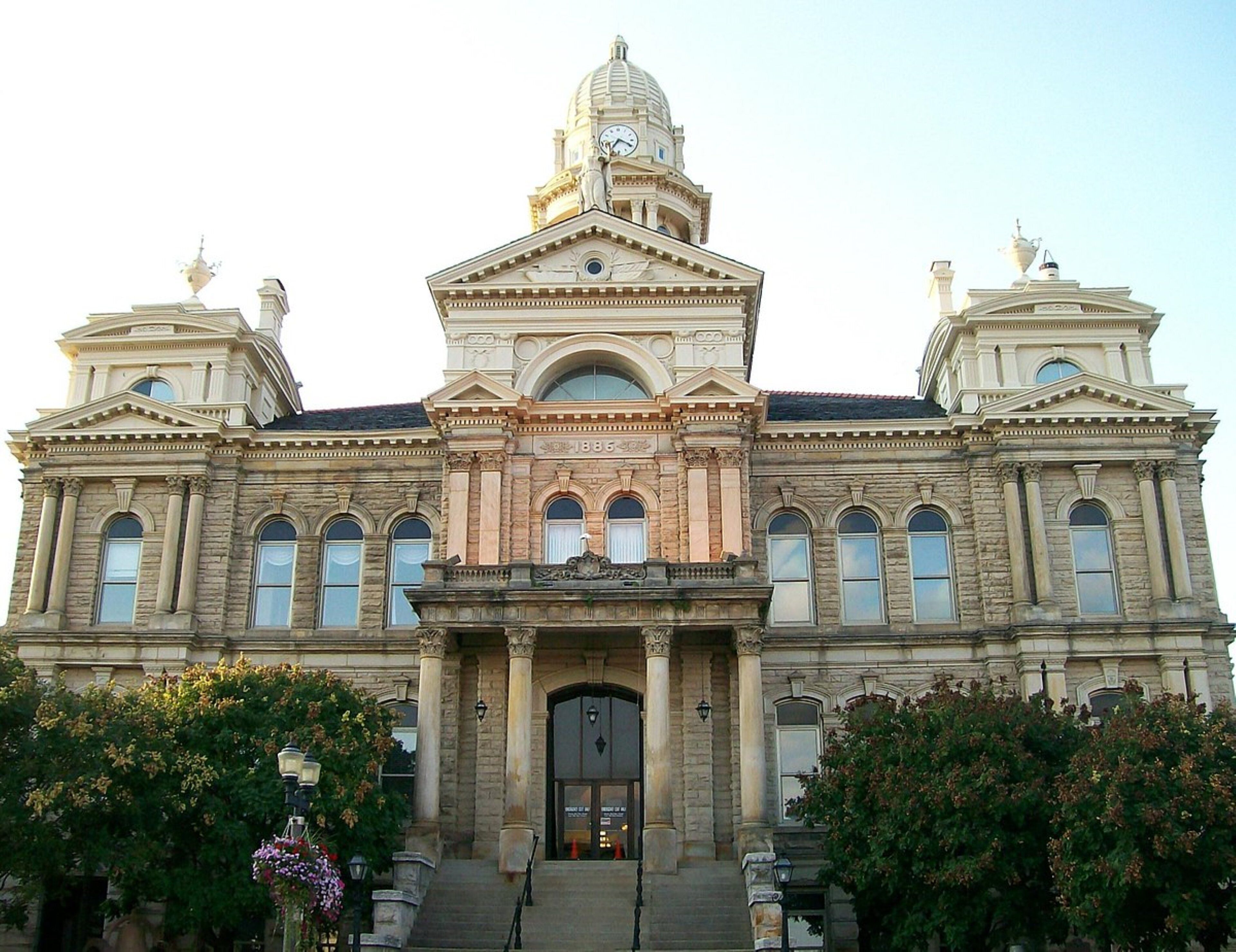 A large, historic building with a central dome, symmetrical wings, and a grand entrance.