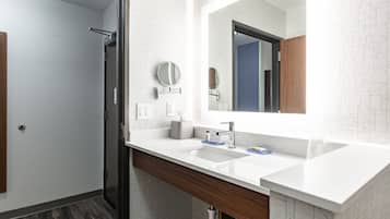 Un baño moderno con dos lavamanos, un espejo grande y una ducha.