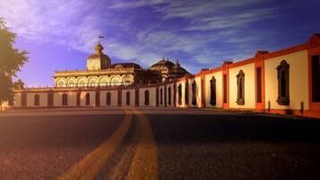 A large, ornate building with domed structures and a long colonnade.