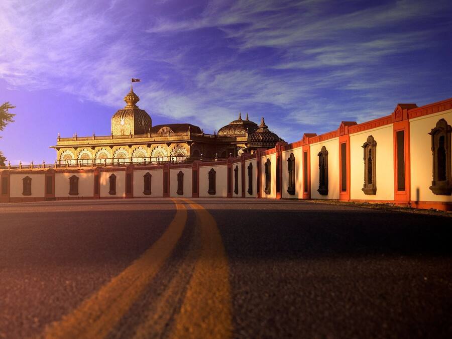 A large, ornate building with domed structures and a long colonnade.