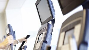 Une pompe à essence dotée d’un écran numérique et d’une main tenant une carte de crédit.