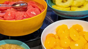 Cuatro cuencos con fruta sobre una mesa.