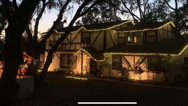 A house with a Tudor-style design, featuring a steeply pitched roof and exposed wooden beams.
