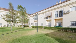 Ein Wohngebäude mit gepflegtem Rasen, einer Straßenlaterne und blauem Himmel.